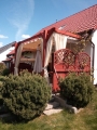Custom waterproof outdoor curtains hanging on a wooden garden pergola with decorative privacy screens.