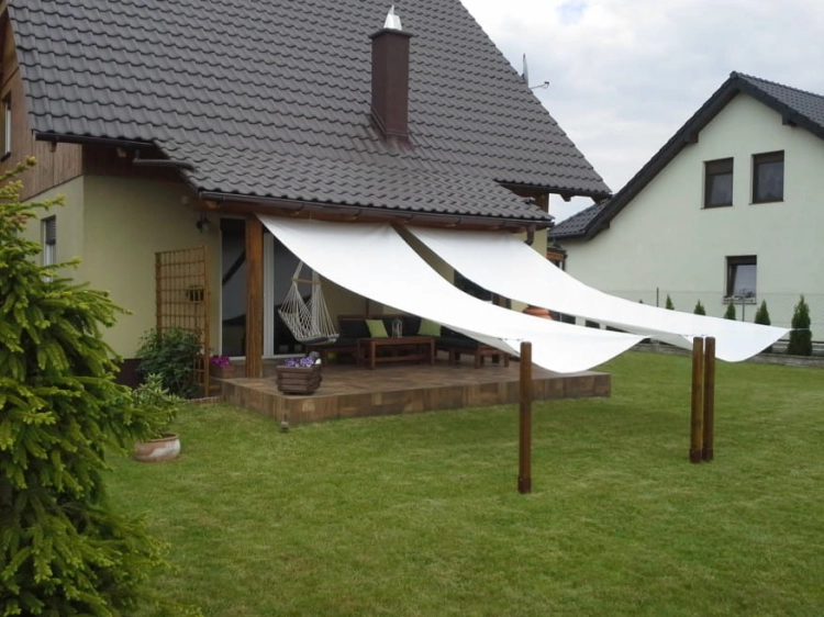 Witte Romeinse zonnedoek 2,1x5 m gemonteerd boven het terras van een eengezinswoning