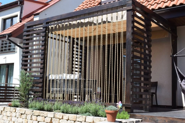Premium 3x4 m waterproof roman blind installed on a dark wood pergola over a terrace with rope side accents.