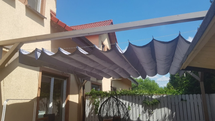 Retractable 3x4 m premium patio roman blind in grey for sun and water protection over a wooden terrace structure