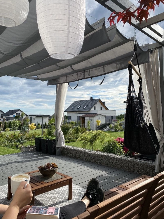 Retractable terrace Roman blind 3x4 m provides sun protection and shade over a modern deck with furniture.
