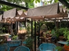 Retractable Roman outdoor canopy providing shade for a garden restaurant patio with waterproof premium fabric.