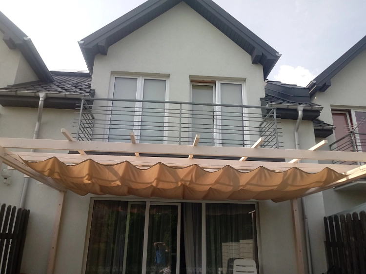 Beiges Premium Sonnensegel wasserdicht und ausziehbar 2,5x5 m montiert an einer Holzpergola auf der Terrasse