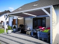 Wasserdichtes Premium Sonnensegel montiert an einer modernen Pergola auf der Terrasse mit Palettenmöbeln