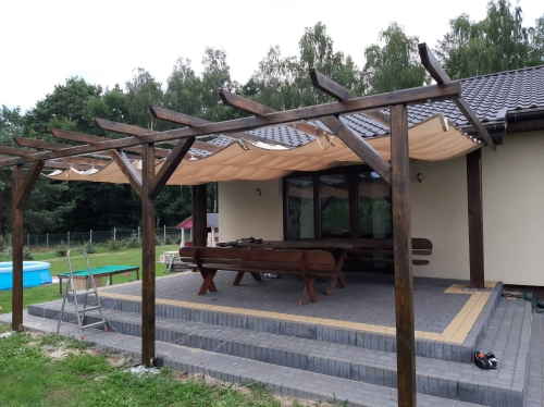 Beiges Premium Sonnensegel wasserdicht ausziehbar 1,5x5 m montiert an einer Holzpergola auf der Terrasse