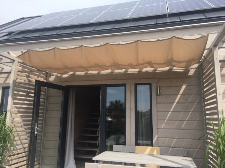 Beiges Premium-Sonnensegel wasserdicht ausziehbar 1,5x5 m montiert an einer Holzpergola auf der Terrasse