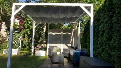 Vela ombreggiante Premium impermeabile ed estensibile montata su una struttura per pergola bianca