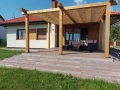 Beigefarbenes Sonnensegel wasserdicht ausziehbar 2,5x4 m montiert an einer Holzpergola über der Terrasse vor dem Haus