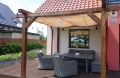 Beiges Sonnensegel wasserdicht ausziehbar 2,5x4 m montiert an einer Holzpergola über Terrassenmöbeln