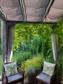 Wasserdichtes Sonnensegel Premium 2,5x4 m an einer Pergola über Holzsesseln mit Kissen montiert