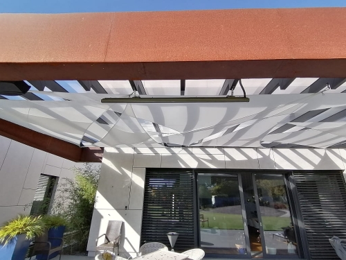 Premium triangular waterproof sun shade sail installed over a modern patio with outdoor heater and furniture