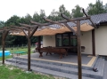 Beiges Sonnensegel wasserdicht ausziehbar 3x3 m montiert unter einer Holzpergola auf der Terrasse am Haus