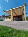 Wasserdichtes, beige Sonnensegel 3x5 m ausziehbar an einer Holzpergola auf der Terrasse eines modernen Hauses