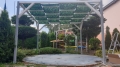 Wasserdichte Pavillonbahn mit grünem Blattmuster, montiert auf einer modernen Pergola-Holzkonstruktion