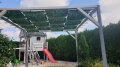 Wasserdichtes Pavillon-Sonnensegel mit grünem Blattmuster montiert an einer Holzpergola im Garten