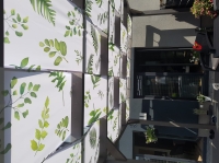 Waterdichte prieelstrook met groene bladerprint gemonteerd op een houten terrasoverkapping