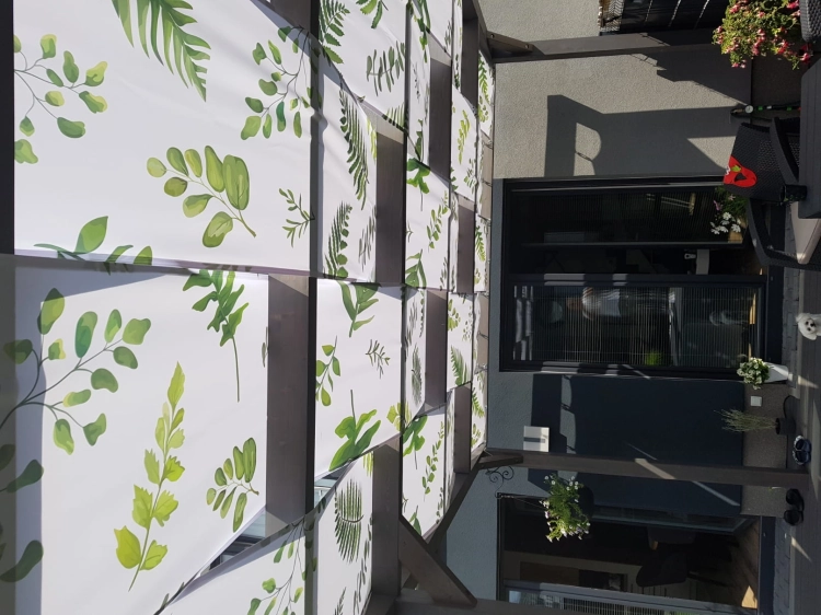 Waterdichte prieelstrook met groene bladerprint gemonteerd op een houten terrasoverkapping