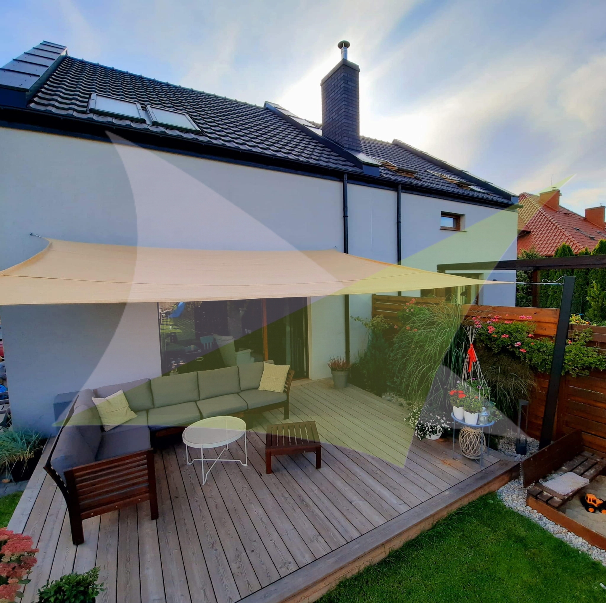 Large 5x6 m rectangular sand-colored HDPE sun sail shade over a modern wooden patio deck with outdoor sofa and table