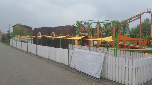 Yellow triangular waterproof garden sails 5x5x7m installed over an outdoor pathway at an amusement park.