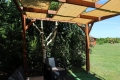 Beigefarbene Sonnenschutz-Gewebebahn aus HDPE-Gewebe, Maße 0,4x5 m, montiert an einer hölzernen Gartenpergola