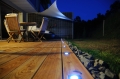 Weißes dreieckiges Premium Sonnensegel über einer Holzterrasse mit Lounge-Möbelset