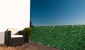 Voordelig balkonscherm met dichte groene haag print gemonteerd op een terrasreling
