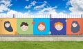 Colorful balcony privacy screen with illustrations of five happy children's faces on a fence in a garden setting