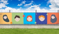 Colorful balcony privacy screen with illustrations of five happy children's faces on a fence in a garden setting