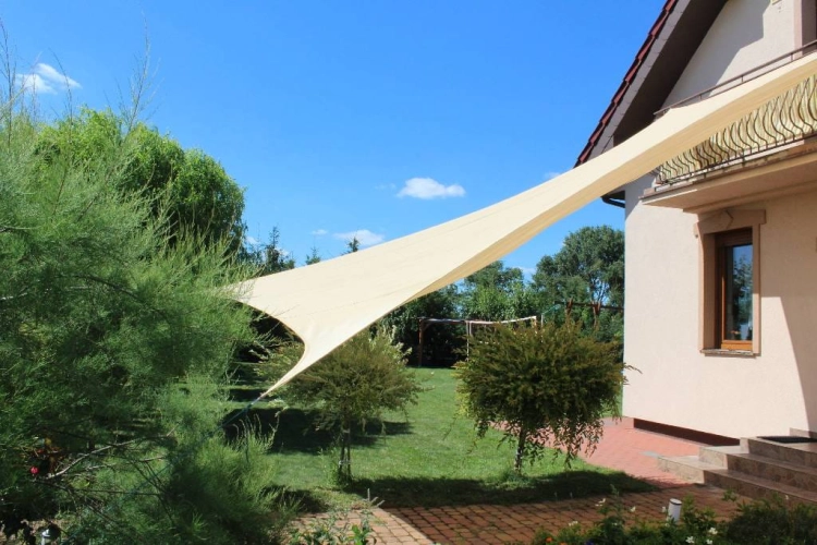 Štvorcová piesková slnečná clona 3x3 m z HDPE namontovaná nad terasou v záhrade pri dome