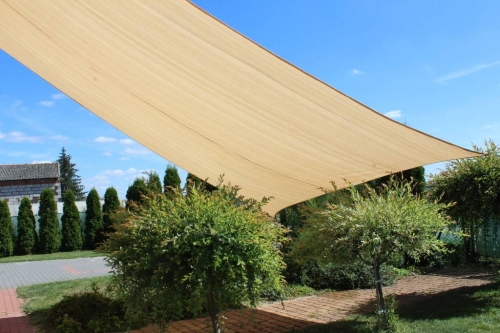 Béžová obdĺžniková slnečná clona 3x4 m z HDPE nad záhradným chodníkom a rastlinami