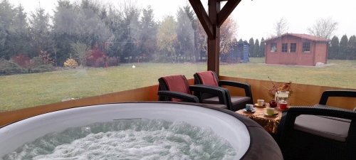 Transparant zeil op maat voor een terras met uitzicht op de tuin, jacuzzi en tuinmeubilair