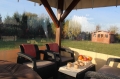 Transparant terraszeil gemonteerd op een houten tuinhuisje met uitzicht op de tuin en het gereedschapsschuurtje