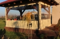 Telone trasparente beige su misura che copre un gazebo da giardino in legno in una giornata di sole