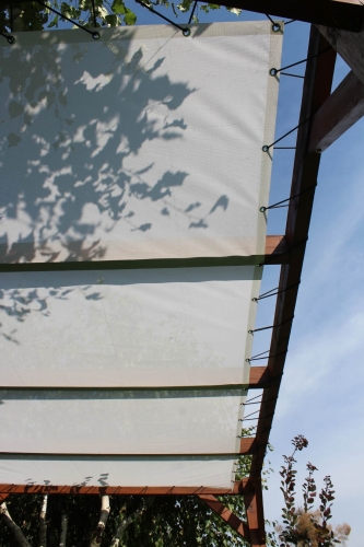 Licht zonnedoek op maat gemonteerd op een houten terrasconstructie