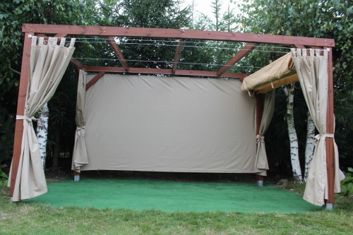 Beige waterdicht tuingordijn op maat gemonteerd op een houten gazebo met groene ondergrond