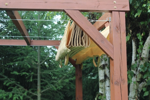 Gefaltetes beige HDPE Sonnenschutz-Raffrollo montiert an einer maßgefertigten Holzperrgoia für die Terrasse