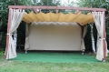 Custom HDPE roman shade canopy and outdoor curtains on a wooden terrace pergola with a green floor base.