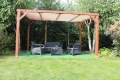 Custom HDPE sun shade sail canopy installed on a wooden pergola over a garden lounge furniture set.