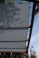 Graues HDPE-Sonnensegel nach Maß, montiert an einer Holzpergola mit Seilen und Ösen