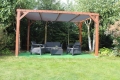 Velă de umbrandă gri din HDPE la comandă montată pe o pergolă din lemn cu mobilier de grădină pe terasă