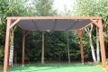 Graues HDPE-Sonnensegel nach Maß, montiert an einer Gartenpergola aus Holz