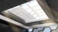Custom retractable wave shade for indoor roof skylights, providing sun protection and soft natural lighting.