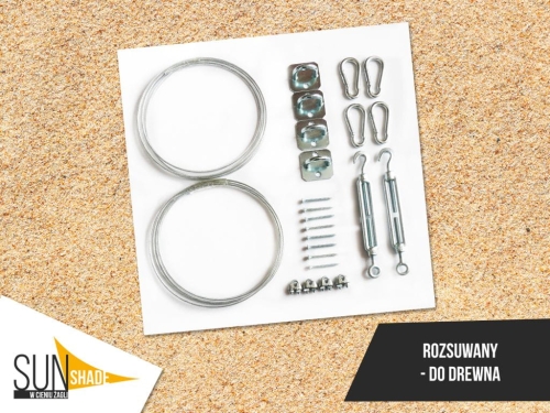 Sunshade kit for wooden roof windows with metal cables, tensioners, screws, and brackets on a sand background