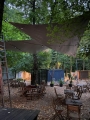 Wasserdichtes dreieckiges PVC-Sonnensegel über Holztischen im Restaurantgarten im Herbst