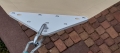 Corner of a waterproof triangular custom sun sail with a metal hook attachment and white reinforced mounting plate.