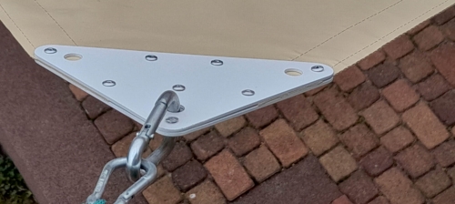 Ecke eines wasserdichten PVC-Sonnensegels mit stabiler Befestigung und Stahlkarabiner