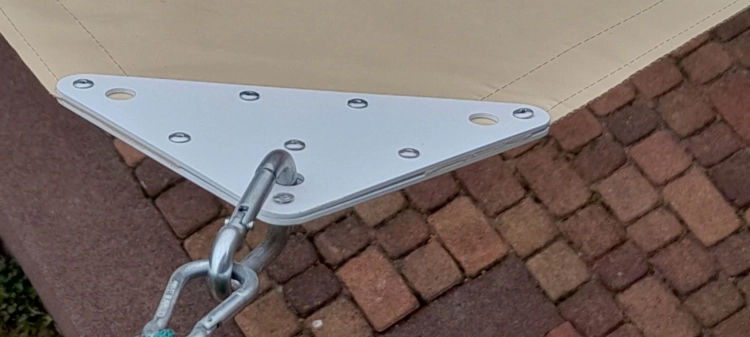 Hoek van een waterdicht PVC schaduwdoek met stevige bevestiging en stalen karabijnhaak