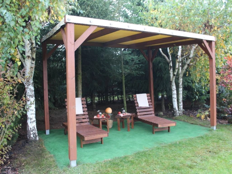 Custom-sized year-round PVC terrace roof on a wooden gazebo with two sun loungers in a lush garden setting
