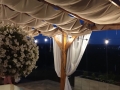 Wasserdichtes, ausziehbares Sonnensegel beige 3x3 m Premium montiert auf einer Holzpergola mit Beleuchtung