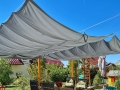 Graues Sonnensegel wasserdicht und ausziehbar Premium Maße 3x3 m über einer Terrasse mit Gartenmöbeln
